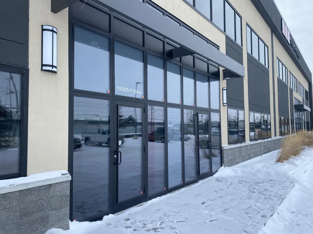 Commercial storefront display windows retrofitted with dark-tinted RockGlass security glazing