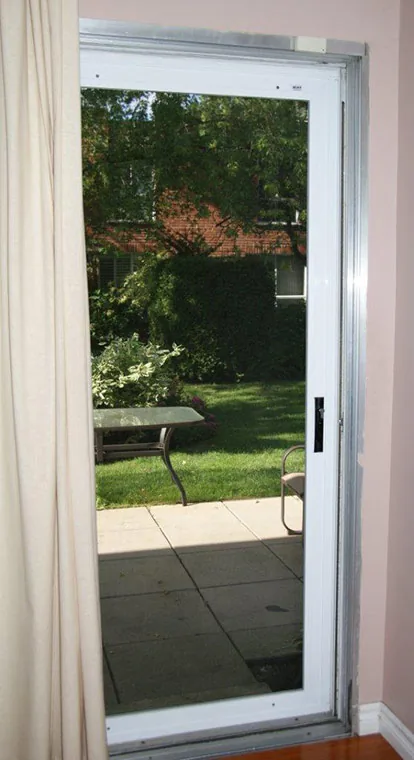 Sliding security screen door installed on a residential patio door opening to the backyard